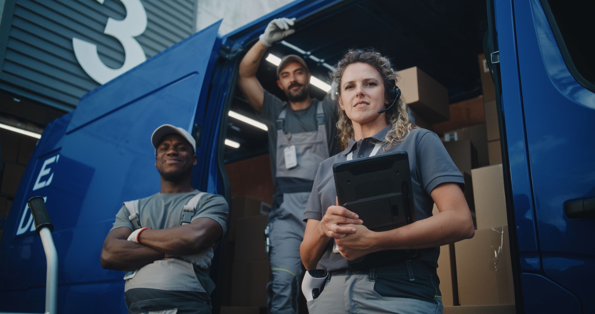 Team of Diverse Workers Standing near Delivery Truck, Looking at Camera